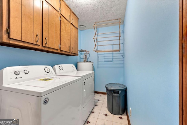 57 Fair Oaks Dr SE, Conyers, GA 30094 - laundry area with cabinet space, washer and clothes dryer, a textured ceiling, baseboards, and water heater