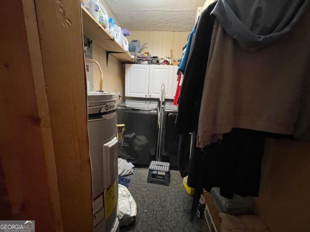 washroom featuring carpet, washing machine and clothes dryer, and a textured ceiling