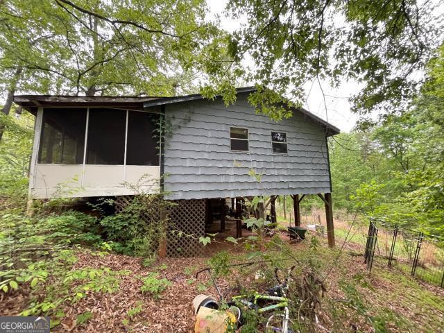 view of property exterior with a sunroom