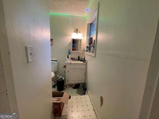 half bathroom featuring tile patterned floors and vanity