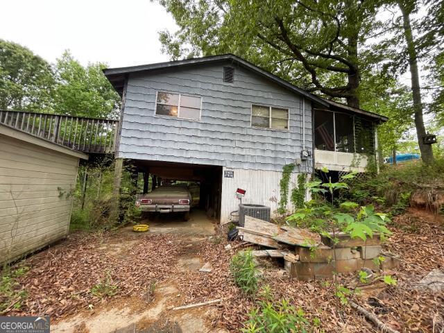 view of property exterior with a carport and central AC