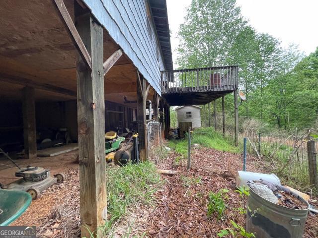 view of yard featuring an outbuilding, a deck, and a shed