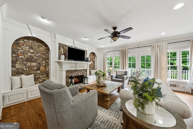 2195 Hickory Hill Rd, Alpharetta, GA 30004 - living room with a ceiling fan, wood finished floors, a fireplace, crown molding, and arched walkways