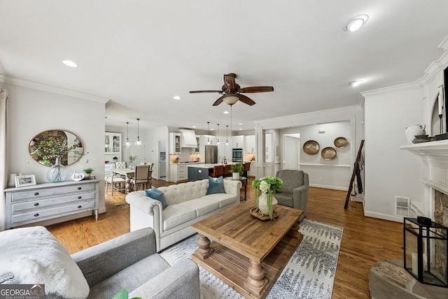 2195 Hickory Hill Rd, Alpharetta, GA 30004 - living room with a fireplace with raised hearth, ceiling fan, ornamental molding, light wood-style floors, and recessed lighting