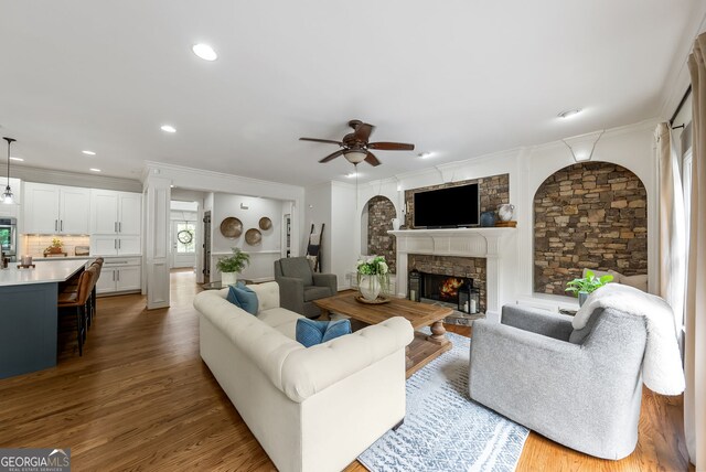 2195 Hickory Hill Rd, Alpharetta, GA 30004 - living room with a ceiling fan, a stone fireplace, wood finished floors, crown molding, and recessed lighting