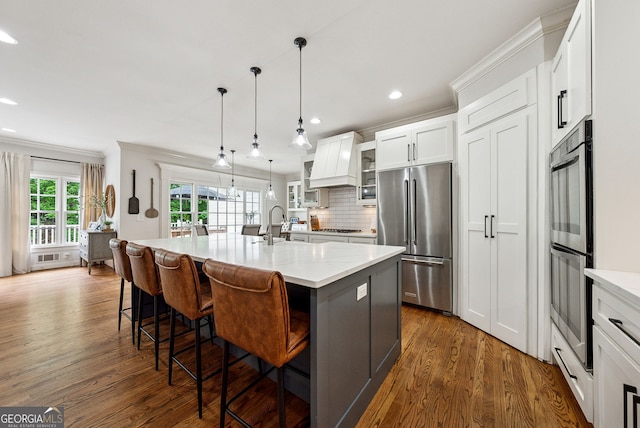 2195 Hickory Hill Rd, Alpharetta, GA 30004 - kitchen featuring stainless steel appliances, dark wood-style floors, glass insert cabinets, a kitchen island with sink, and recessed lighting