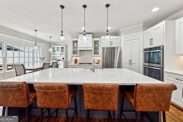 2195 Hickory Hill Rd, Alpharetta, GA 30004 - kitchen with appliances with stainless steel finishes, decorative backsplash, glass insert cabinets, ornamental molding, and a breakfast bar