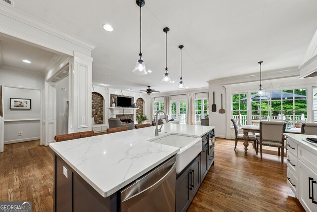 2195 Hickory Hill Rd, Alpharetta, GA 30004 - kitchen featuring stainless steel dishwasher, a sink, a warm lit fireplace, crown molding, and a ceiling fan