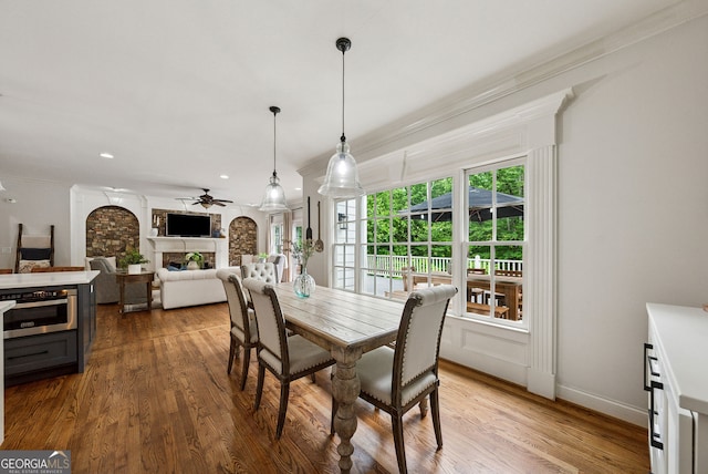 2195 Hickory Hill Rd, Alpharetta, GA 30004 - dining room featuring a ceiling fan, a fireplace, wood finished floors, crown molding, and baseboards