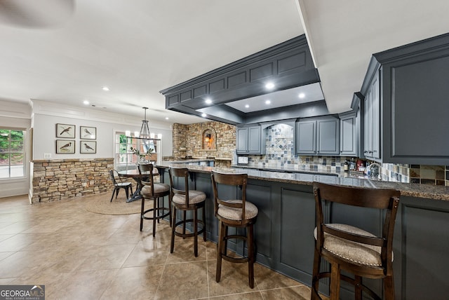 2195 Hickory Hill Rd, Alpharetta, GA 30004 - kitchen with ornamental molding, backsplash, dark stone counters, a chandelier, and a kitchen bar