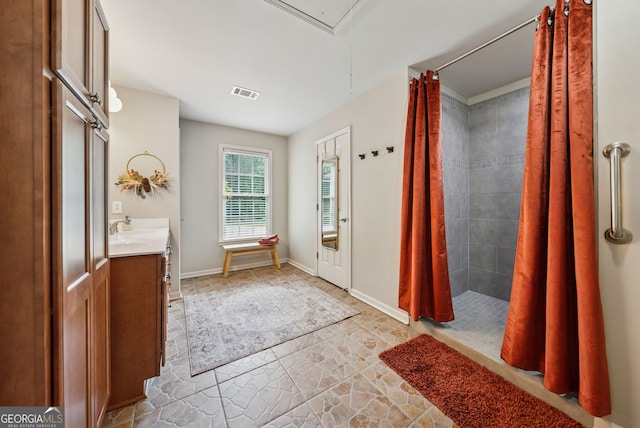 2195 Hickory Hill Rd, Alpharetta, GA 30004 - full bathroom with stone finish floors, a tile shower, vanity, and baseboards