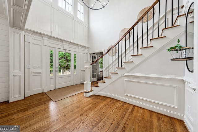 2195 Hickory Hill Rd, Alpharetta, GA 30004 - foyer featuring a decorative wall, a towering ceiling, healthy amount of natural light, wood finished floors, and stairs