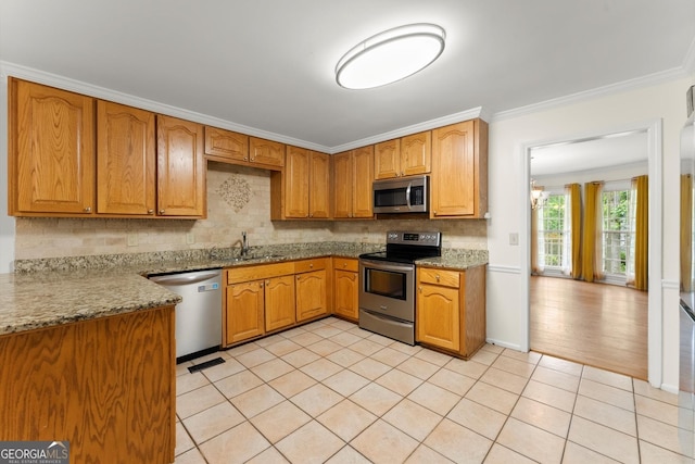 1713 Dudley Dr, Woodstock, GA 30188 - kitchen featuring stainless steel appliances, backsplash, crown molding, light tile patterned floors, and brown cabinetry