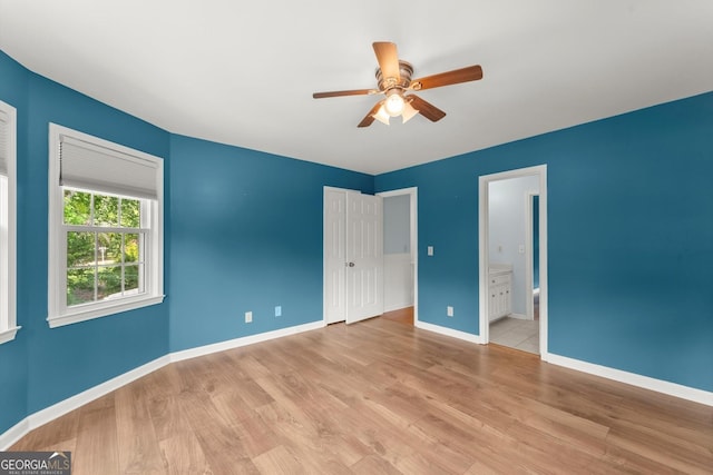 1713 Dudley Dr, Woodstock, GA 30188 - unfurnished bedroom with light wood-style floors, a closet, ensuite bath, and ceiling fan