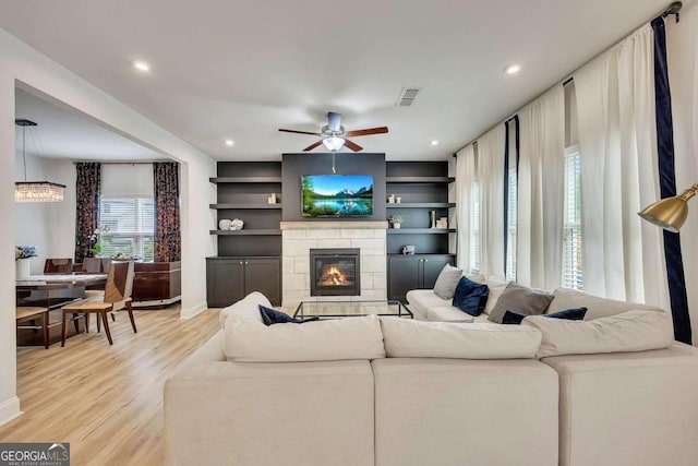 165 Brookstone Park E, Acworth, GA 30101 - living area with light wood-style flooring, a glass covered fireplace, a ceiling fan, baseboards, and recessed lighting