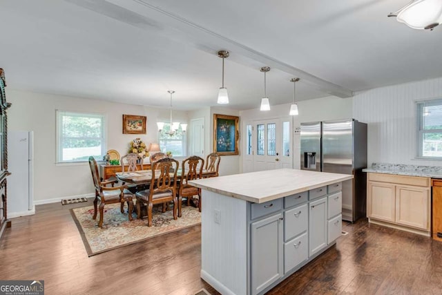 kitchen with stainless steel fridge, light countertops, dark wood-type flooring, and a chandelier