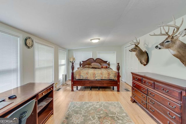 bedroom featuring lofted ceiling and light wood-type flooring