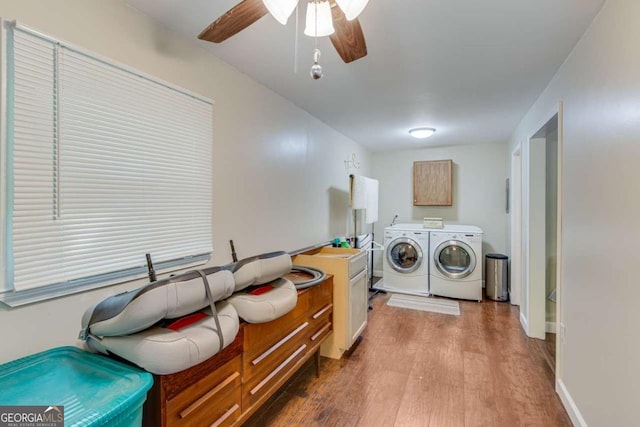 clothes washing area with separate washer and dryer, wood finished floors, cabinet space, a ceiling fan, and baseboards