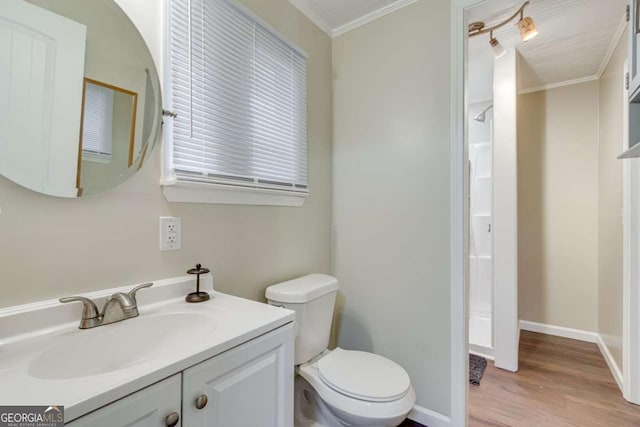 bathroom with crown molding, wood finished floors, vanity, toilet, and baseboards