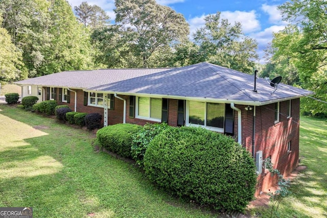 single story home with brick siding, a shingled roof, and a front lawn