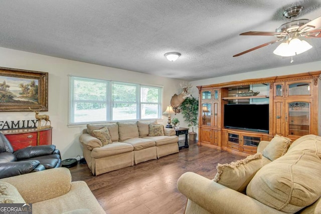 living room featuring wood finished floors, a ceiling fan, and a textured ceiling