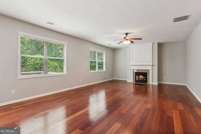 5655 Stevehaven Ln, Cumming, GA 30028 - unfurnished living room featuring ceiling fan, a glass covered fireplace, wood finished floors, and baseboards
