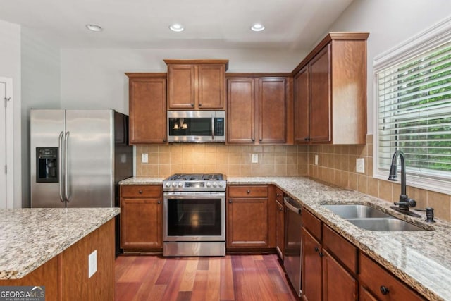 5655 Stevehaven Ln, Cumming, GA 30028 - kitchen featuring stainless steel appliances, a sink, dark wood-style floors, light stone countertops, and backsplash