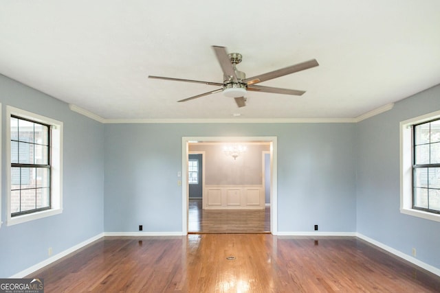 1878 Blalock Ave, Waycross, GA 31503 - unfurnished room featuring wood finished floors, healthy amount of natural light, ceiling fan, a chandelier, and crown molding