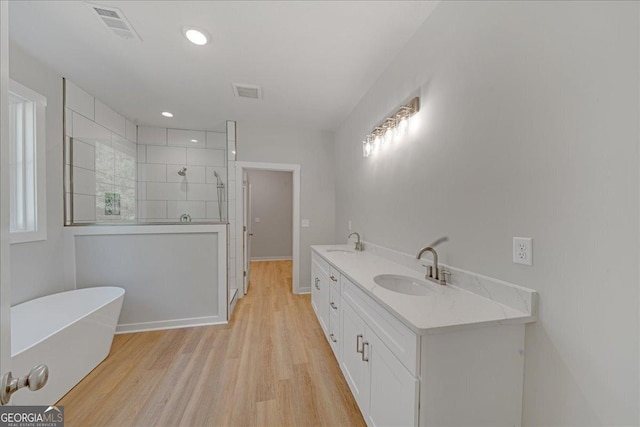 1186 Snow Hill Rd, Cadwell, GA 31009 - bathroom with tiled shower, a soaking tub, wood finished floors, double vanity, and baseboards