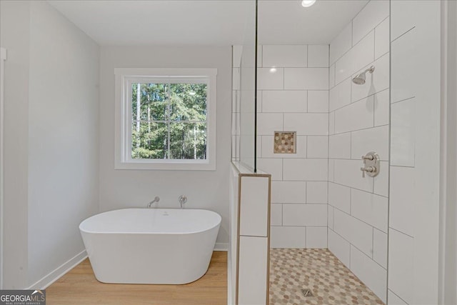 1186 Snow Hill Rd, Cadwell, GA 31009 - bathroom featuring walk in shower, a freestanding bath, wood finished floors, and baseboards