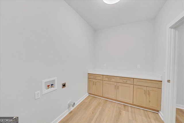 1186 Snow Hill Rd, Cadwell, GA 31009 - laundry area with hookup for an electric dryer, hookup for a washing machine, light wood-style floors, cabinet space, and baseboards