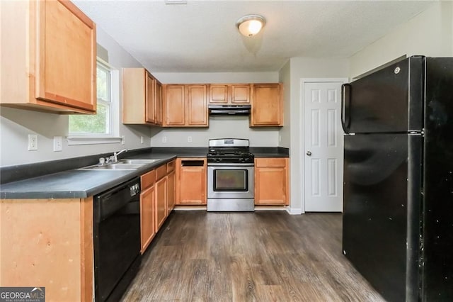 kitchen featuring black appliances, under cabinet range hood, dark countertops, and dark wood finished floors
