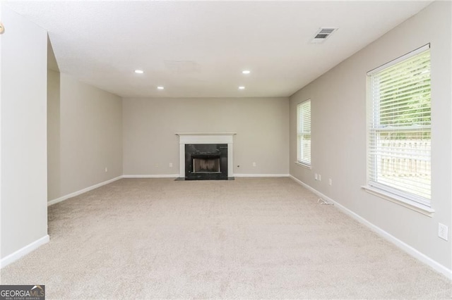 unfurnished living room with light carpet, recessed lighting, a fireplace, and baseboards