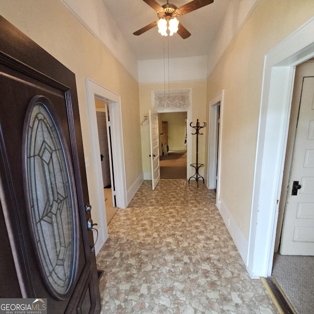 foyer featuring a ceiling fan and baseboards