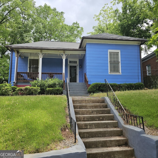 view of front of house featuring a front yard, a porch, and stairway
