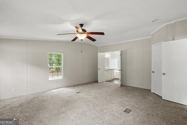 carpeted empty room with a ceiling fan and a textured ceiling