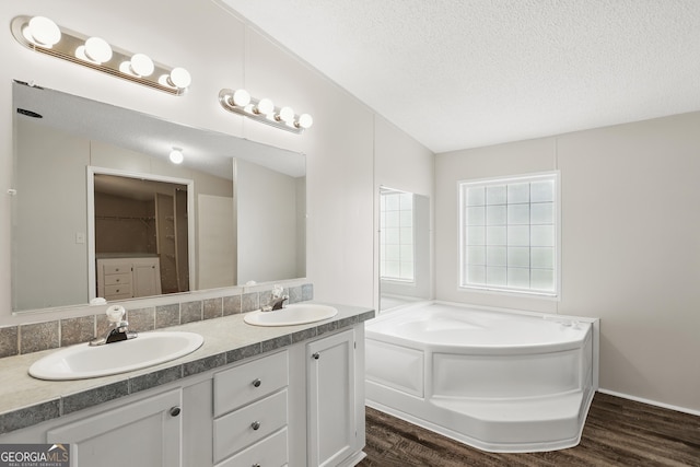 2830 Rincon Stillwell Rd, Rincon, GA 31326 - full bathroom with double vanity, wood finished floors, a textured ceiling, a bath, and a walk in closet