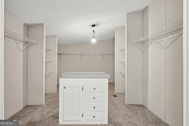 walk in closet featuring light colored carpet