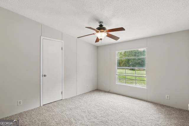 spare room with carpet floors, ceiling fan, and a textured ceiling