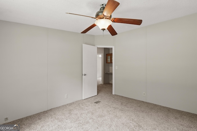 carpeted empty room with a ceiling fan