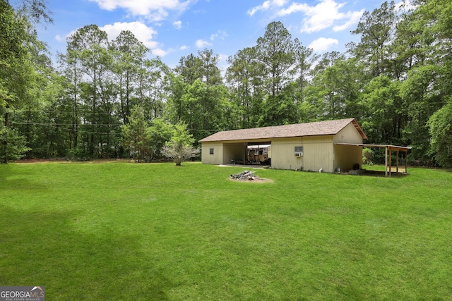 view of green lawn with an outbuilding and a carport