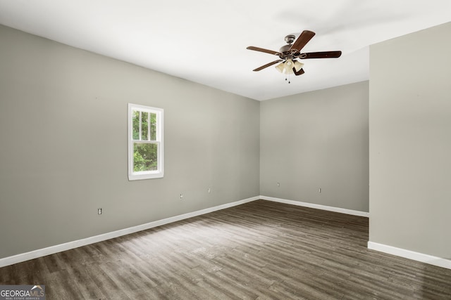 empty room with baseboards, dark wood-style flooring, and ceiling fan