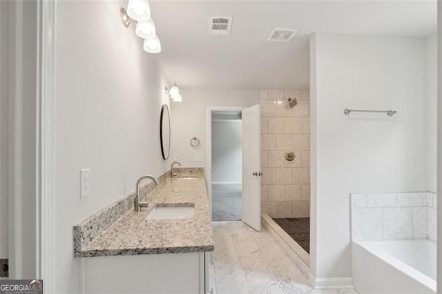 bathroom featuring marble look tile flooring, a garden tub, a tile shower, and double vanity