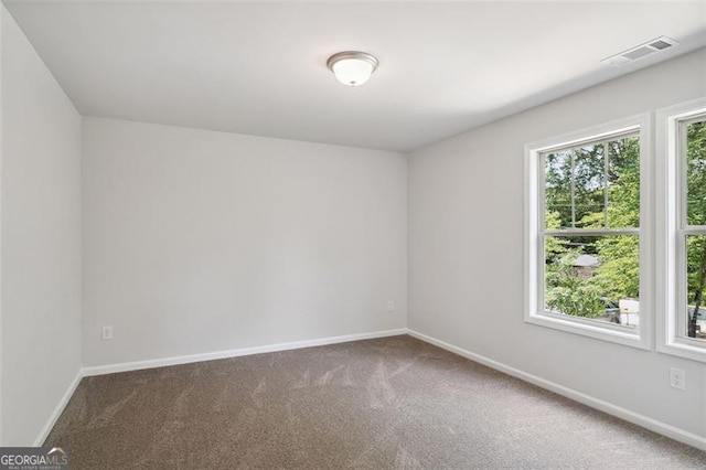 empty room featuring plenty of natural light, carpet, and baseboards