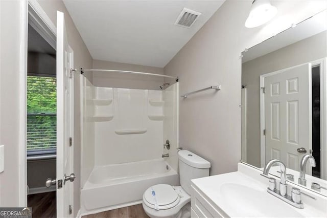 5290 Forest Downs Ln, Atlanta, GA 30349 - bathroom with toilet, wood finished floors, vanity, and shower / tub combination