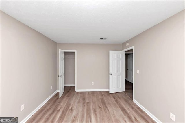 5290 Forest Downs Ln, Atlanta, GA 30349 - unfurnished bedroom featuring light wood-style floors, baseboards, and a closet
