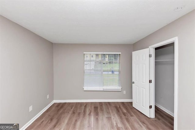 5290 Forest Downs Ln, Atlanta, GA 30349 - unfurnished bedroom with wood finished floors, baseboards, and a closet