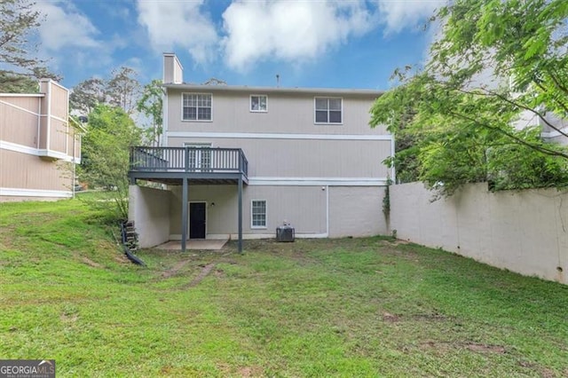 5290 Forest Downs Ln, Atlanta, GA 30349 - back of property with a wooden deck, a lawn, a chimney, and central AC unit