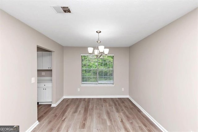 5290 Forest Downs Ln, Atlanta, GA 30349 - unfurnished dining area with light wood-type flooring, a chandelier, and baseboards