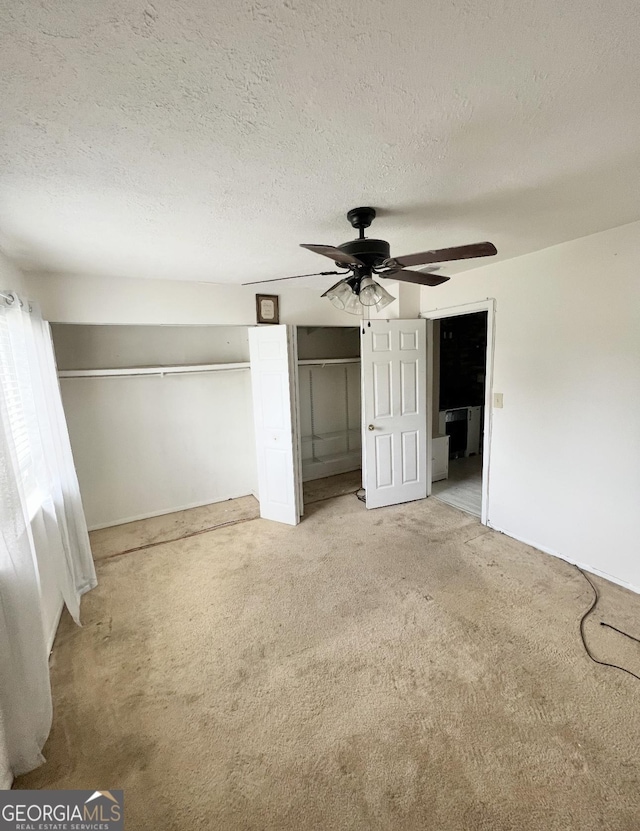1625 Conley Rd Unit 139, Conley, GA 30288 - unfurnished bedroom featuring light colored carpet, a textured ceiling, two closets, and a ceiling fan